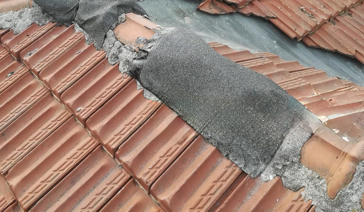 Travaux de mise hors d’eau sur une toiture en tuiles endommagée après une tempête